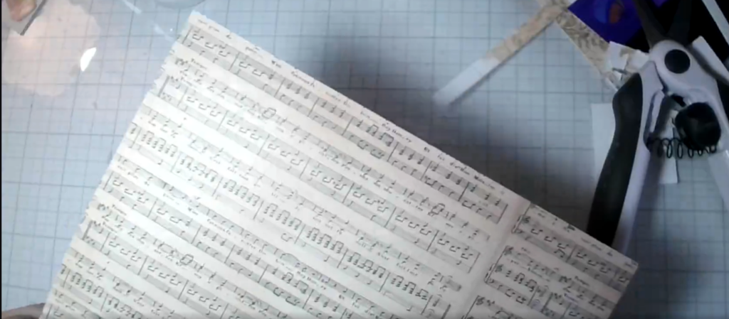 Beige and cream paper printed with musical notation, ready to be used as a card front.